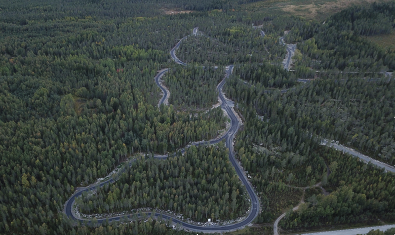 Bild ovanifrån på en asfalterad slinga i skogen